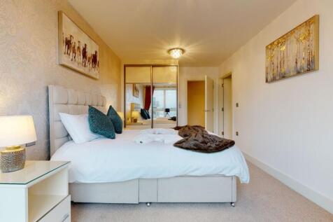 A bright and elegant master bedroom featuring a...