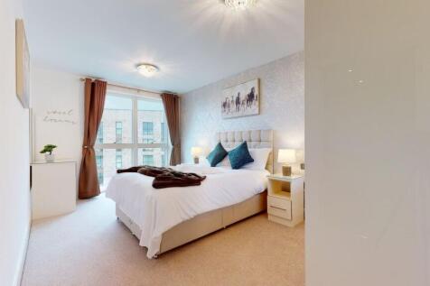 A modern master bedroom featuring a comfortable...