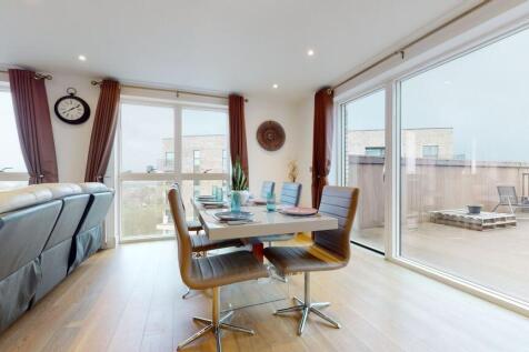 A bright and modern living room featuring large...