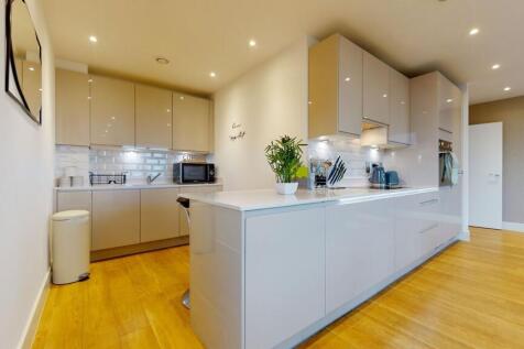 A modern kitchen featuring sleek cabinetry, a s...