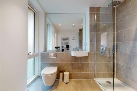 This sleek bathroom features modern beige tiles...