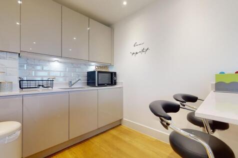A modern, sleek kitchen featuring glossy cabine...