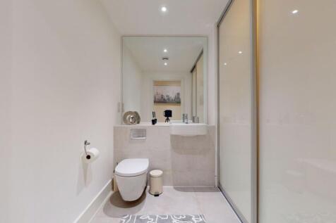 A modern and pristine single toilet space featu...