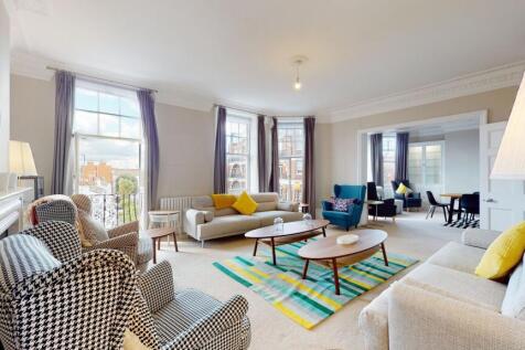 A bright and spacious living room with large sa...