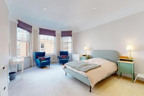 A spacious master bedroom featuring a comfortab...