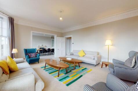 A spacious and stylish living room featuring tw...