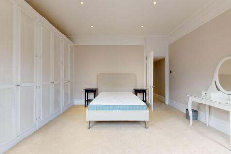 A spacious double bedroom featuring a neatly ma...