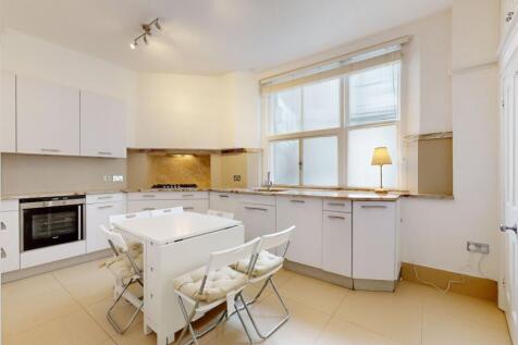 Bright and modern kitchen featuring sleek white...