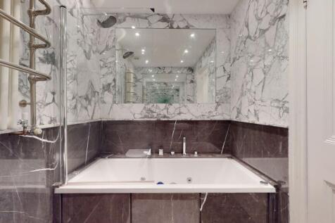 A stylish bathroom suite featuring a large bath...