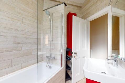 Bright and modern bathroom suite featuring a st...