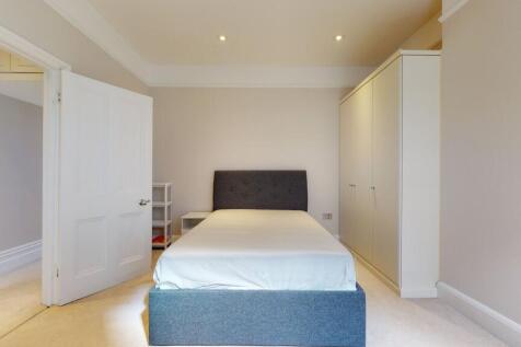 A neat and well-lit double bedroom featuring a ...