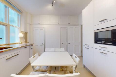 Bright and modern kitchen featuring sleek white...