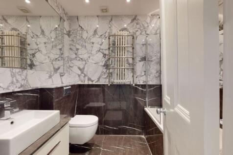A sleek bathroom suite featuring elegant marble...