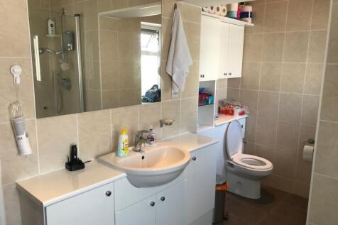 A modern bathroom featuring a large mirror abov...