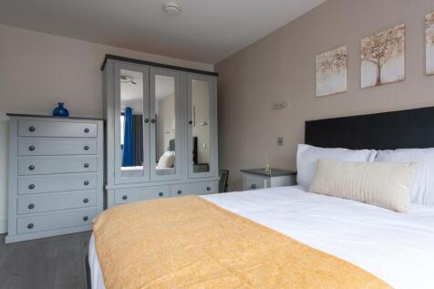 Bright and tidy master bedroom featuring a comf...