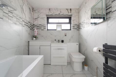 A pristine, modern bathroom featuring sleek whi...
