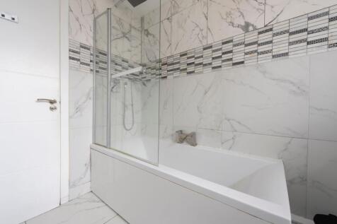 A modern bathroom featuring a sleek white batht...