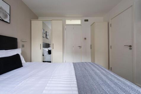 A clean and modern double bedroom featuring a n...