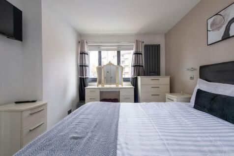 A clean and well-furnished double bedroom featu...