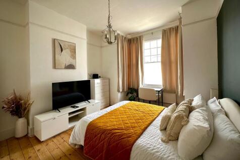 A bright and inviting master bedroom featuring ...