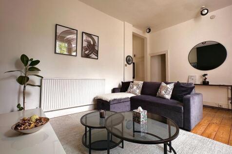 A cozy and stylish living room featuring a plus...