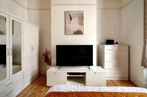 A bright and tidy double bedroom featuring a sl...
