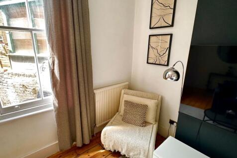 A cozy corner of a living room featuring a comf...