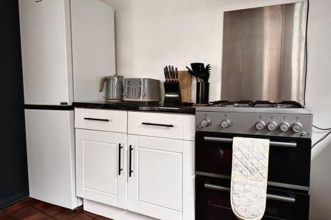 A modern kitchen featuring a clean white fridge...