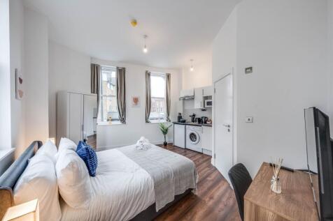 Bright and modern master bedroom featuring a co...