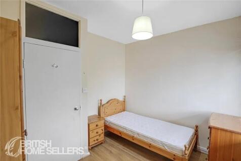 A neat and tidy single bedroom with wooden furn...