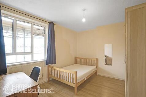 Bright double bedroom featuring a wooden bed fr...
