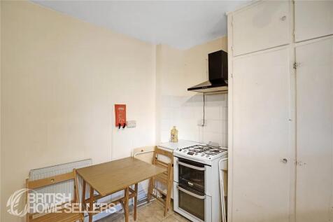A compact kitchen featuring a gas stove with ov...