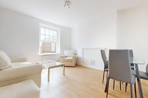 Bright and airy living room featuring light woo...