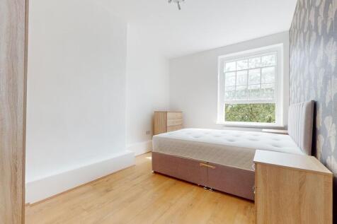A bright and airy double bedroom featuring a la...