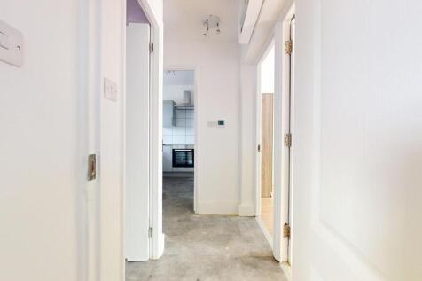 Bright and clean hallway with white walls leadi...