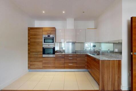 A modern kitchen featuring stylish wood cabinet...
