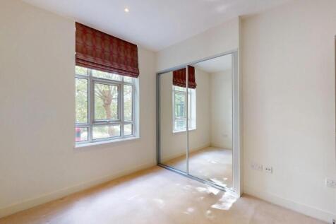 A bright double bedroom featuring a large windo...