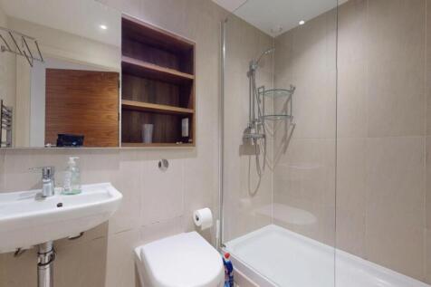 Modern bathroom suite featuring a clean white s...