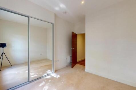 A bright and clean bedroom featuring a large mi...