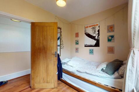 A cozy single bedroom featuring a neatly made s...