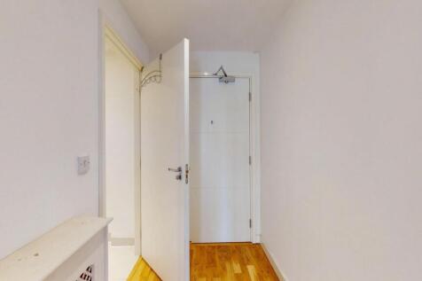 Bright and clean hallway featuring polished woo...