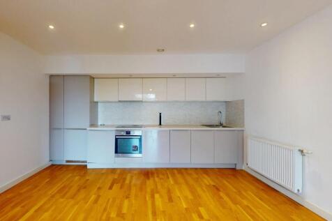 Modern kitchen featuring sleek white cabinetry,...