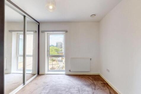 A bright double bedroom featuring a large mirro...