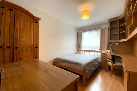 A cozy double bedroom featuring natural wood fu...