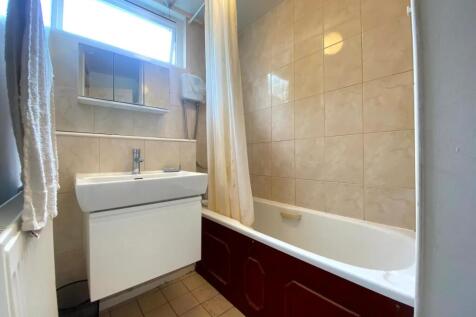 A well-lit bathroom featuring a clean white sin...