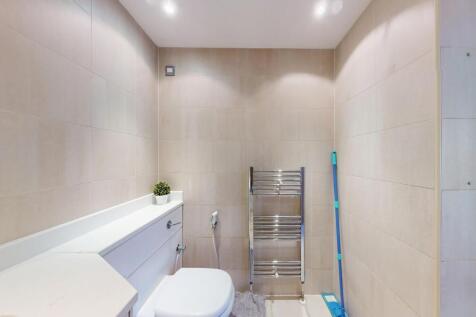 A clean and modern bathroom featuring beige wal...