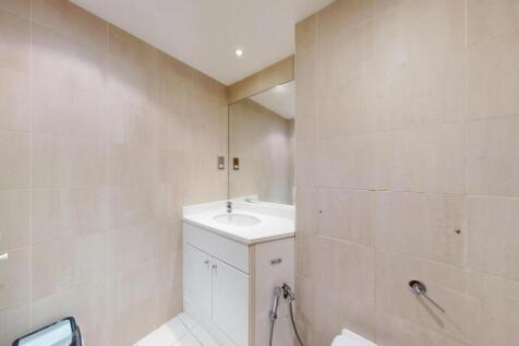 A clean and modern bathroom with beige tiled wa...