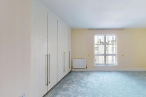 Bright and airy bedroom featuring built-in ward...