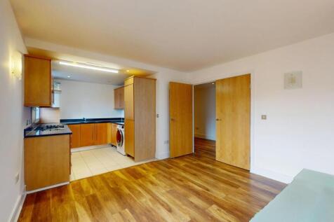 Modern kitchen area with wooden cabinets and bl...
