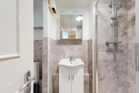 A clean and modern bathroom featuring a shower ...